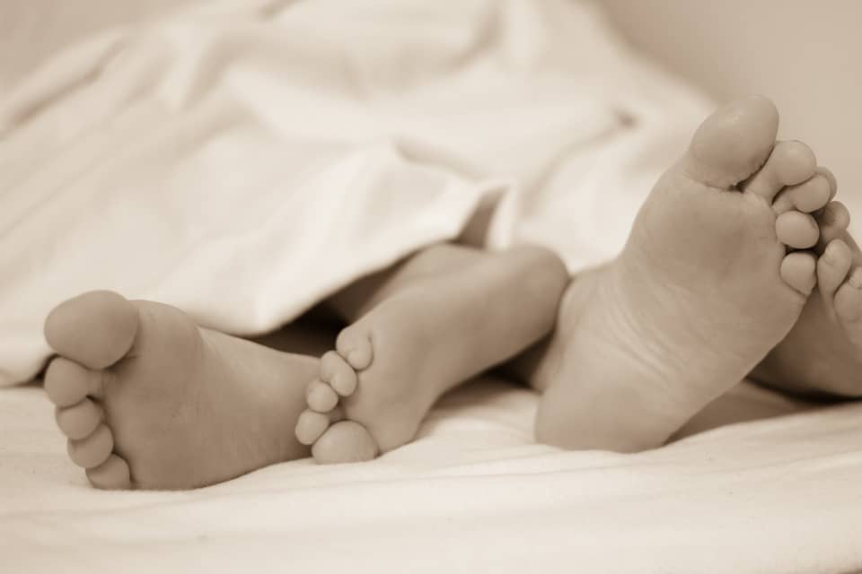 couple's feet on bed